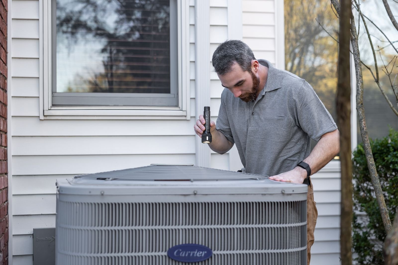 Technician inspecting an outdoor unit